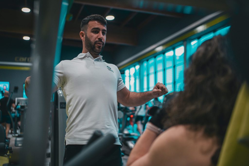A man in a white shirt is in a gym